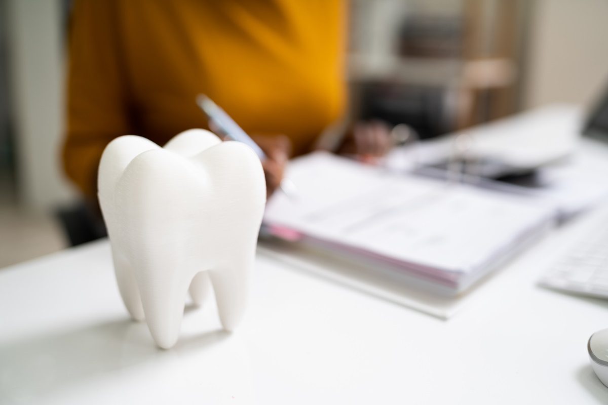 Dental Insurance. Dentist Checking Finance Bill In Office